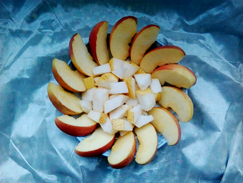 将切好的苹果块和梨块依次摆在盘子里,做成太阳花的形状.