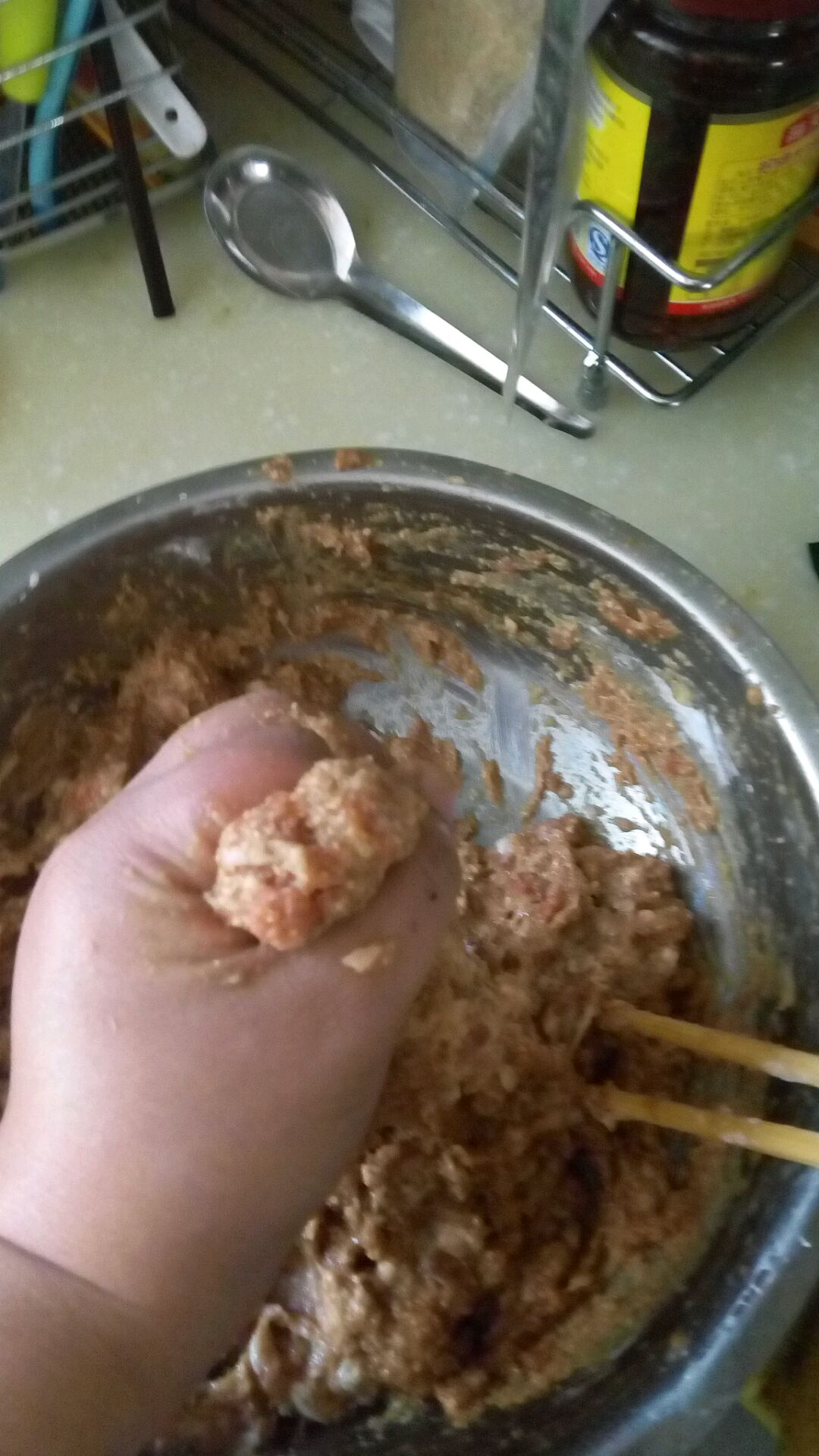 搅拌均匀,从虎口挤丸子,用勺子规整圆,下油锅炸制