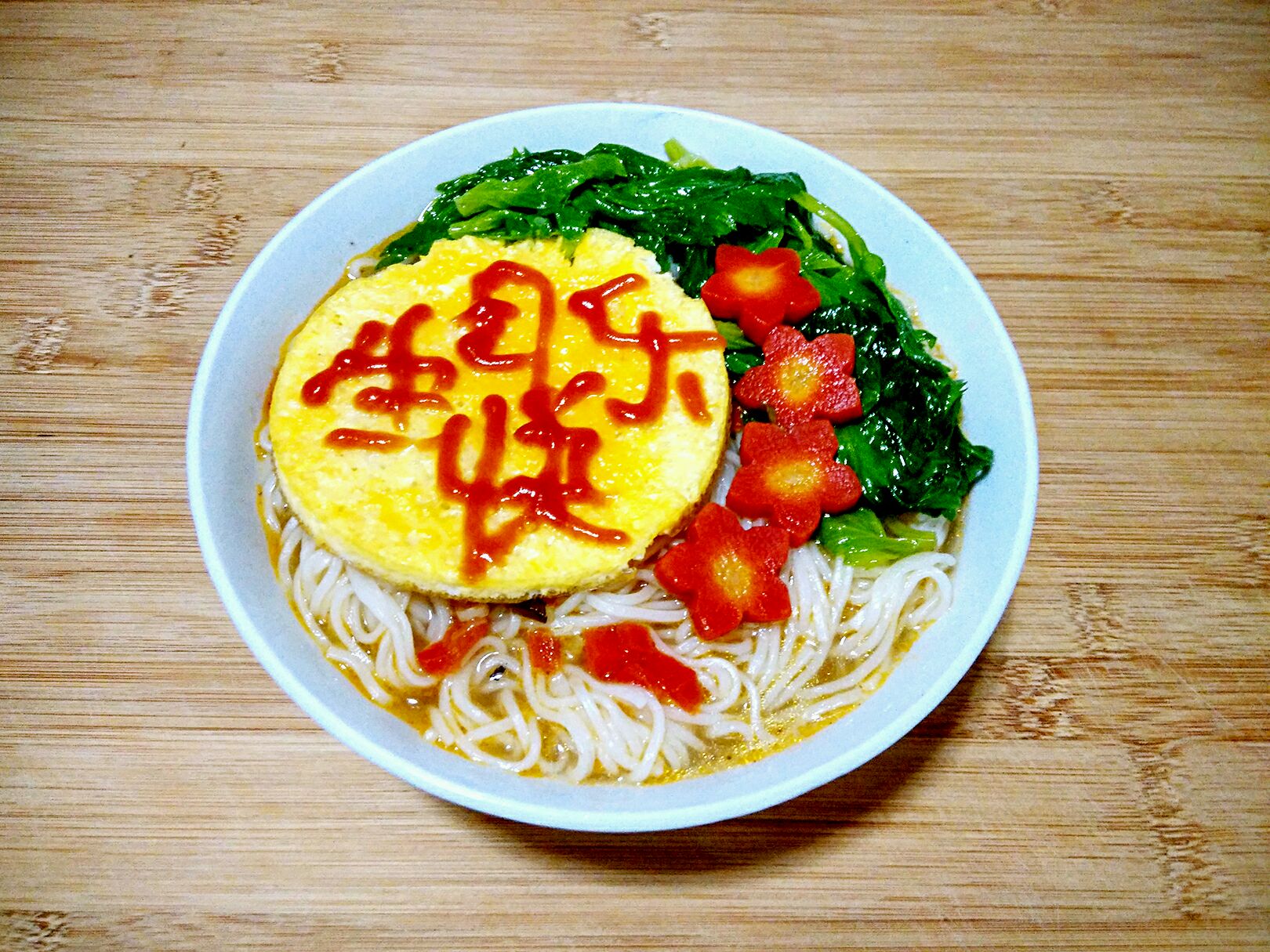 给煮好的面条里面加汤,摆好煎蛋,芹菜叶和红萝卜花,高大上的长寿面做
