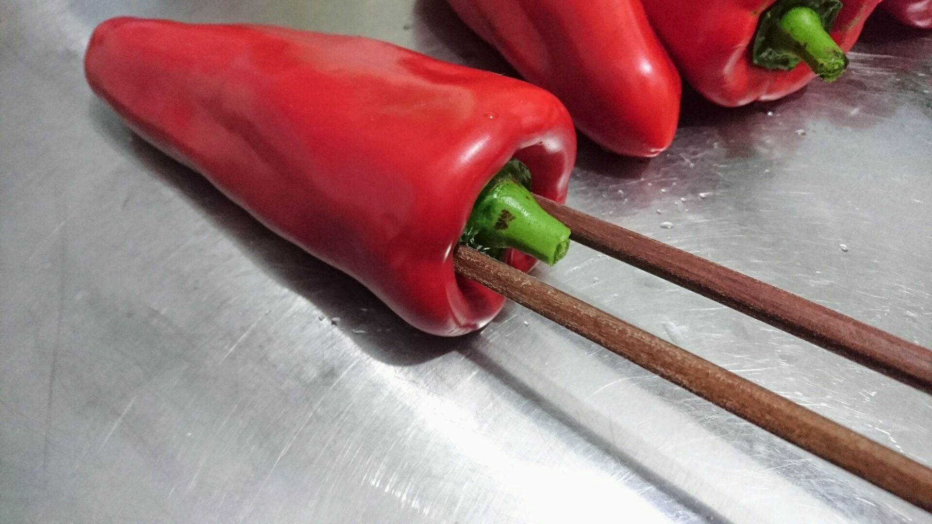 长筷子插入尖椒.如果家里有烧烤网夹,有烧烤铁棒,就最适合了.