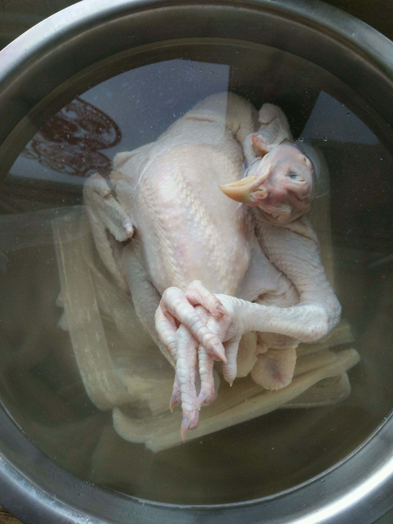 我买的是冷冻的三黄鸡所以要泡下热水解冻,然后剁碎,还有一起泡着的
