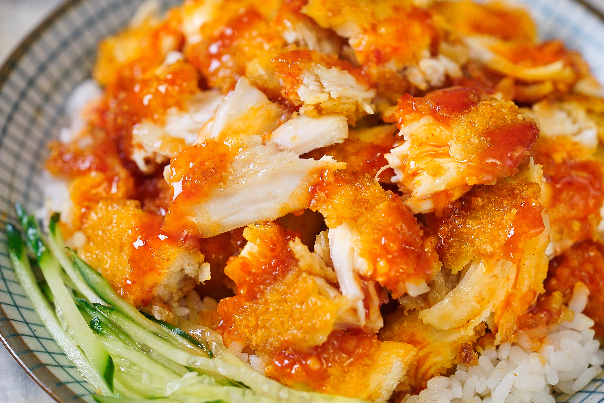 铺在热乎的米饭上,配点黄瓜丝,挤上泰式甜辣酱,脆皮鸡饭完成!
