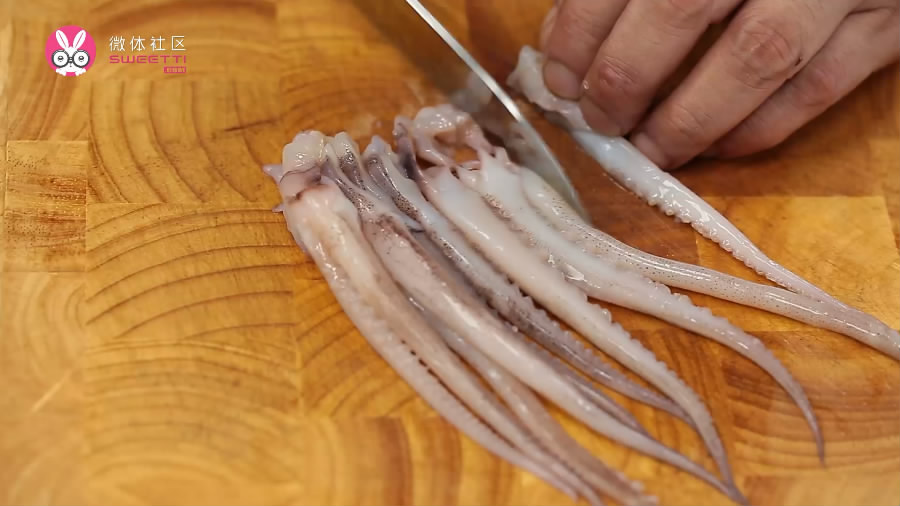 鱿鱼改刀去掉眼睛和嘴,沿着鱿鱼须切成条.