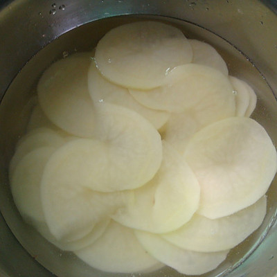 2. 将切好的土豆片在清水中浸泡一下,洗掉表面的淀粉保持口感