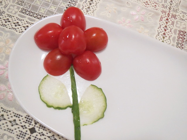 圣女果花朵,圣女果对半剖开,茎是黄瓜皮,叶子是黄瓜片雕的.