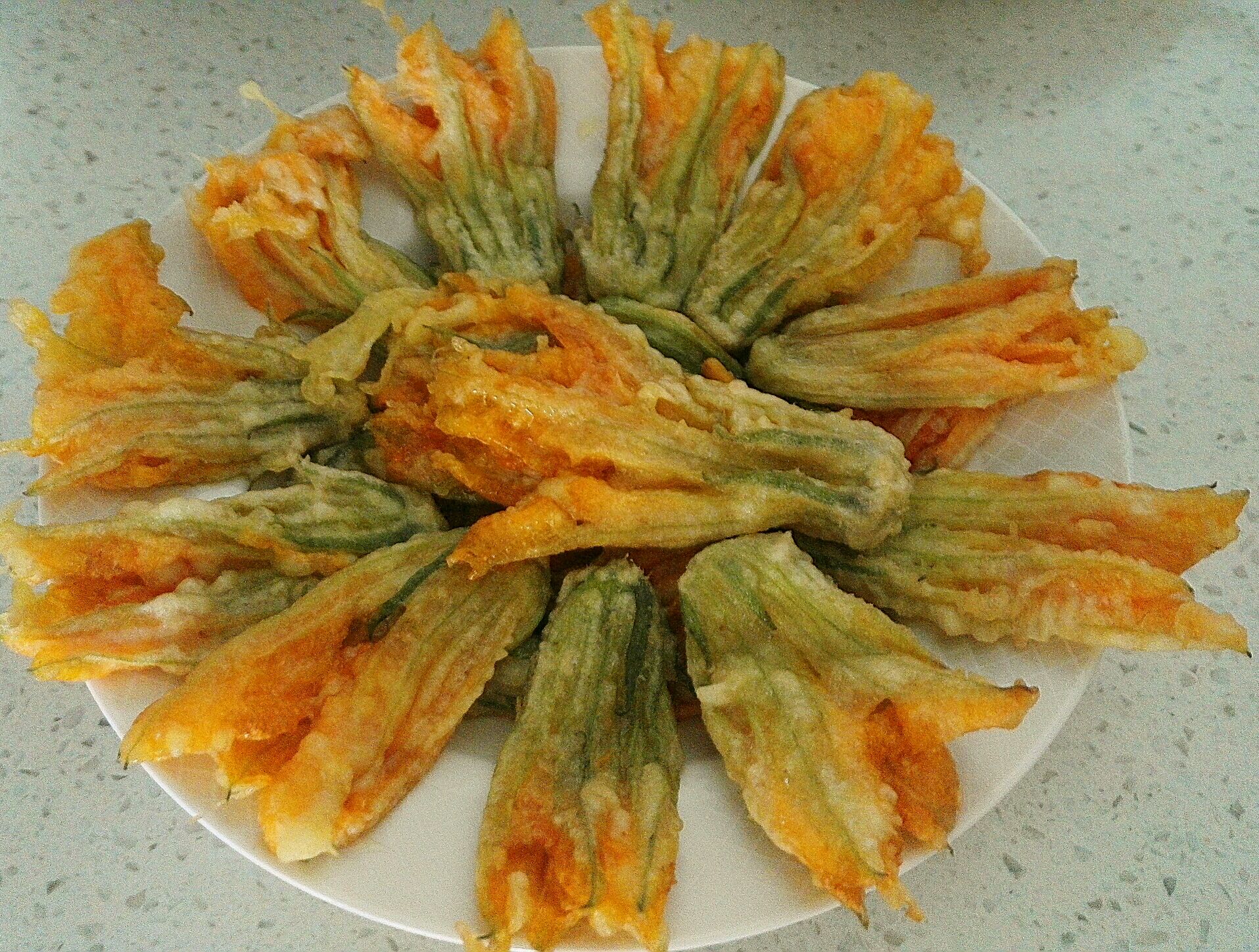 南瓜花500g 淀粉适量 油适量 面粉适量 鸡蛋一个适量 椒盐粉适量 酥炸
