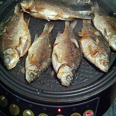 2.在电饼铛上刷薄油,用烤鱼档将小鱼烤成两面焦黄就可了,又脆又香哦.
