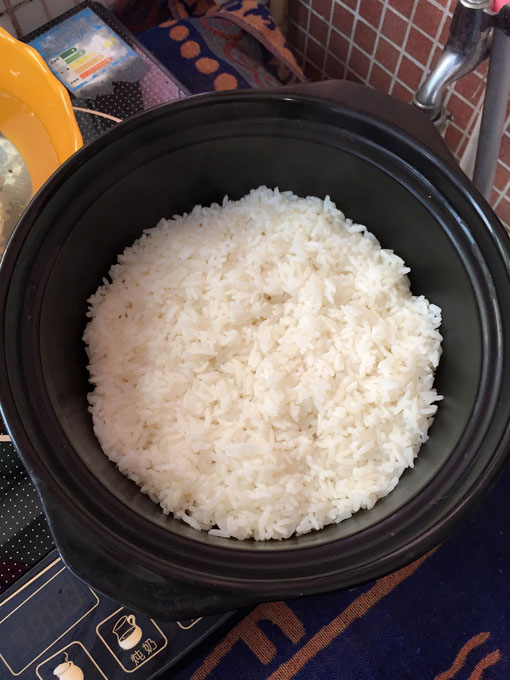 那是因为,饭是电饭锅煮的,现成的.煲仔抹了一层油,再把米饭铺上去.
