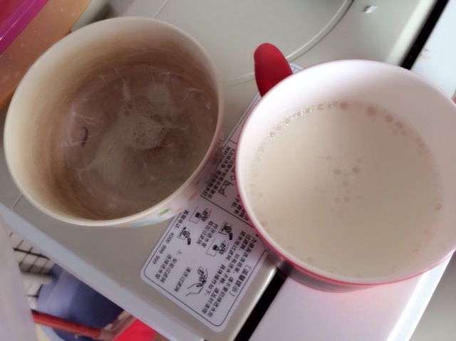 在碗边缘将奶皮划开一道小口,将牛奶倒入另一个容器中待用.
