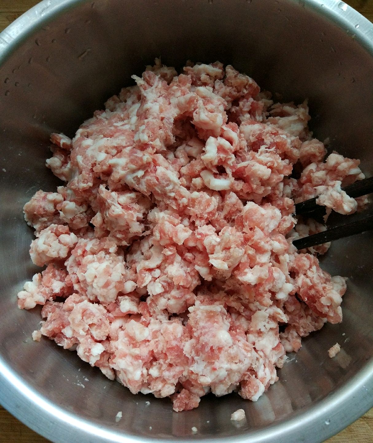 新鲜五花肉馅盛入盆中.