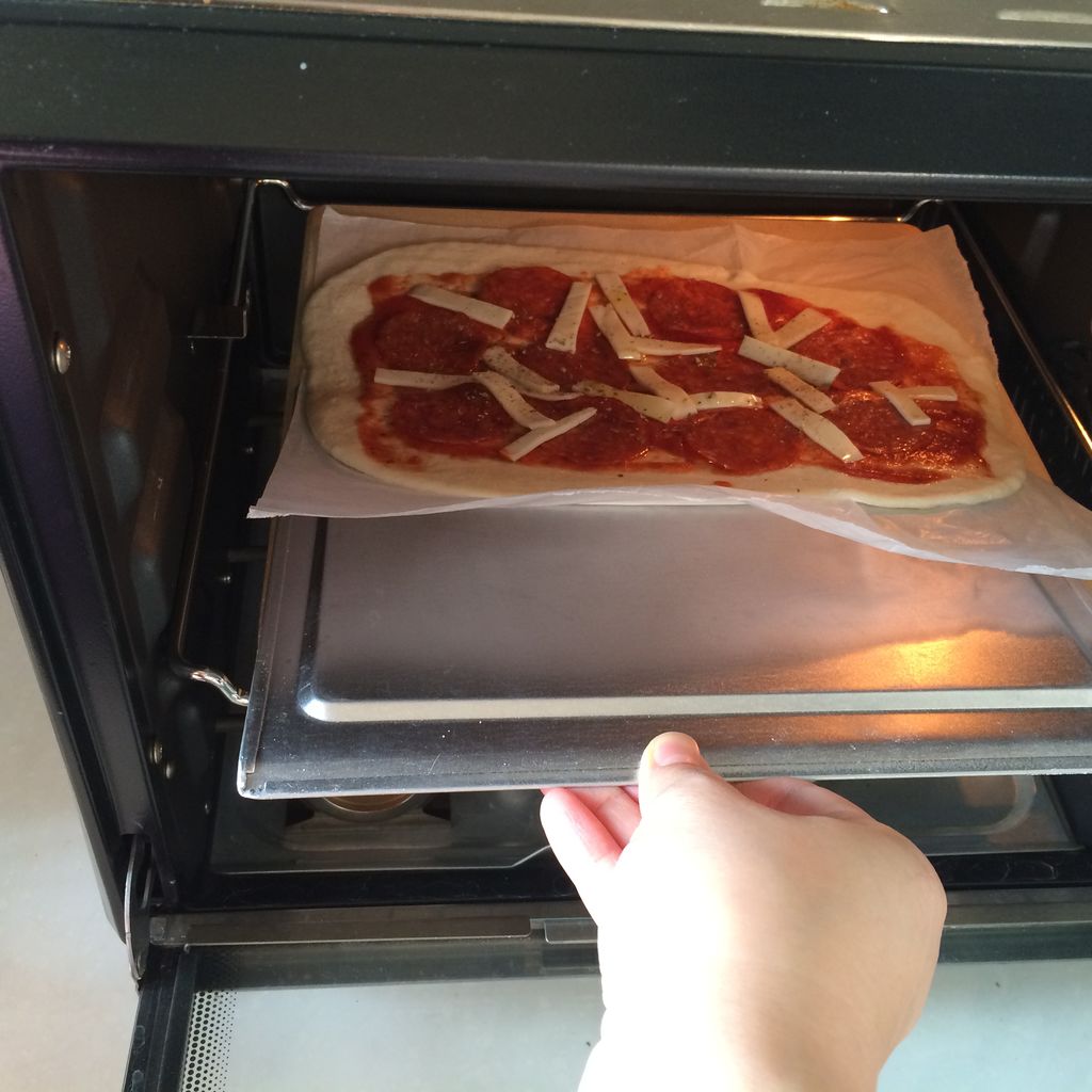 用披萨铲连油纸一起送进烤箱里的石板上,温度改成上下200度,烤13min