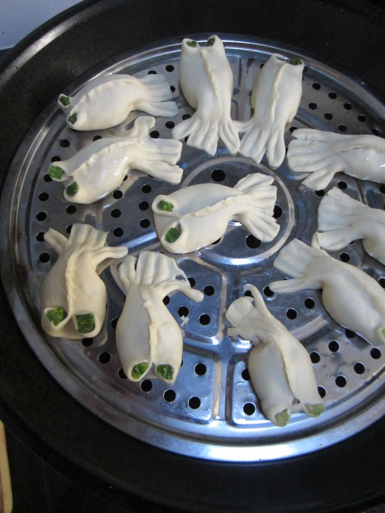 蒸笼底部刷一层油,整齐摆放包好的鱼形饺子,大火蒸约钟,转小火,熟