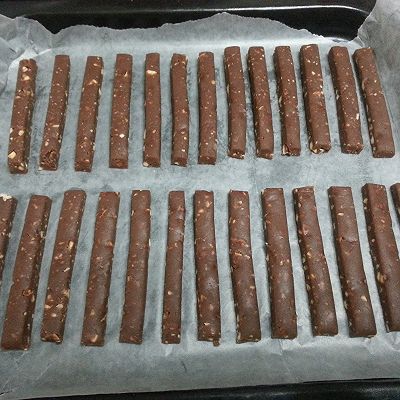 烤盘铺油纸,轻轻将饼干棍与保鲜袋分离,轻轻移到烤盘中.