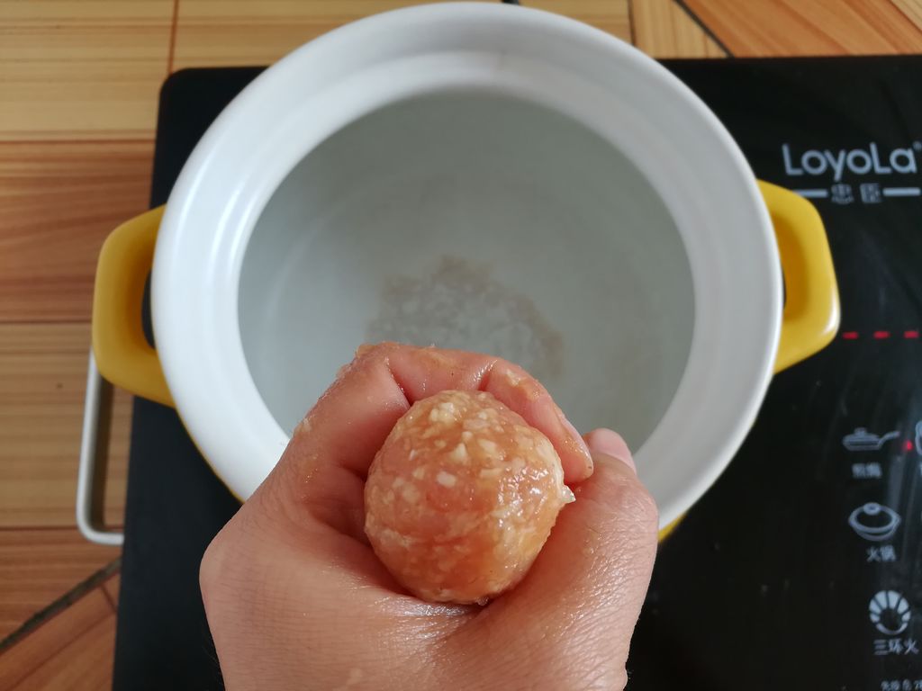 砂锅里装适量的清水,用手的虎口把丸子挤出来