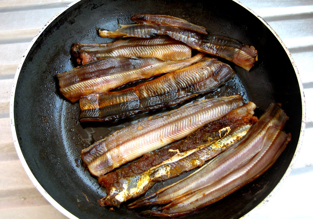 烧热锅子,涂一薄层油,放入腌好的鳗鱼肉片煎制.