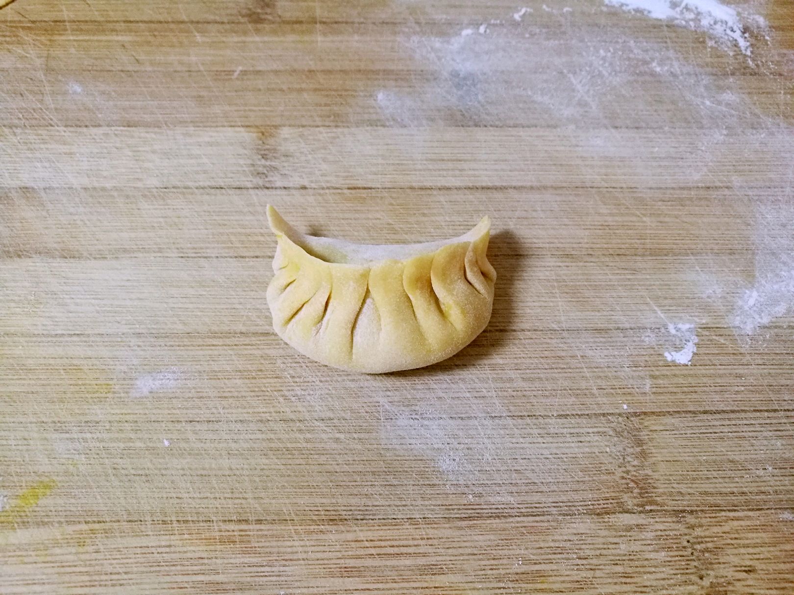 再把另一边捏出褶子,一个月牙自己就包好了,依次做好剩下的饺子皮.