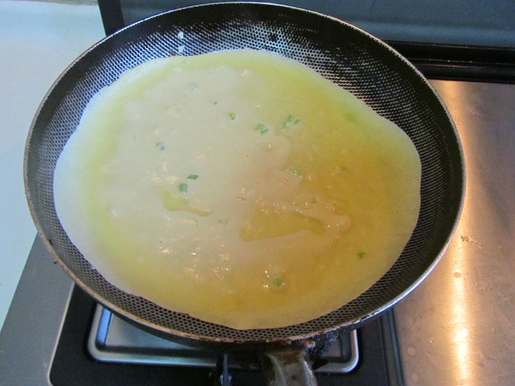 锅离火, 倒入准备好的鸡蛋面糊, 旋转锅, 让面糊均匀的铺在锅底