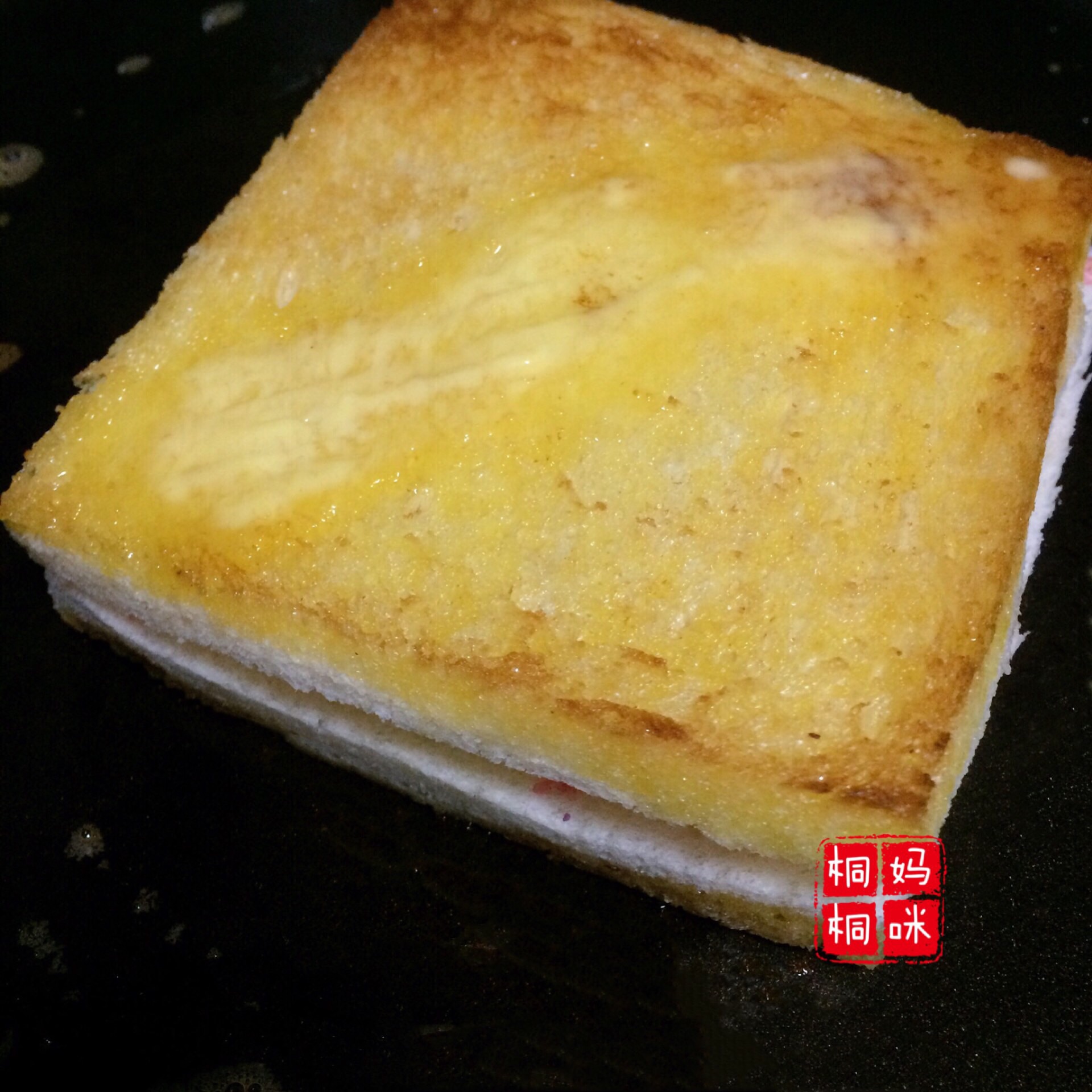 这时趁热,拿羊毛小刷子(烧烤的刷子)在平底锅沾点黄油扫在吐司片上
