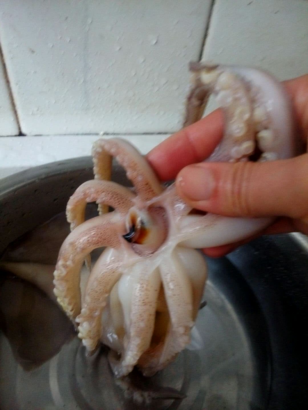 先来处理鱿鱼头,用手指将鱿鱼的两半据说是牙疼的硬壳从背面顶出.