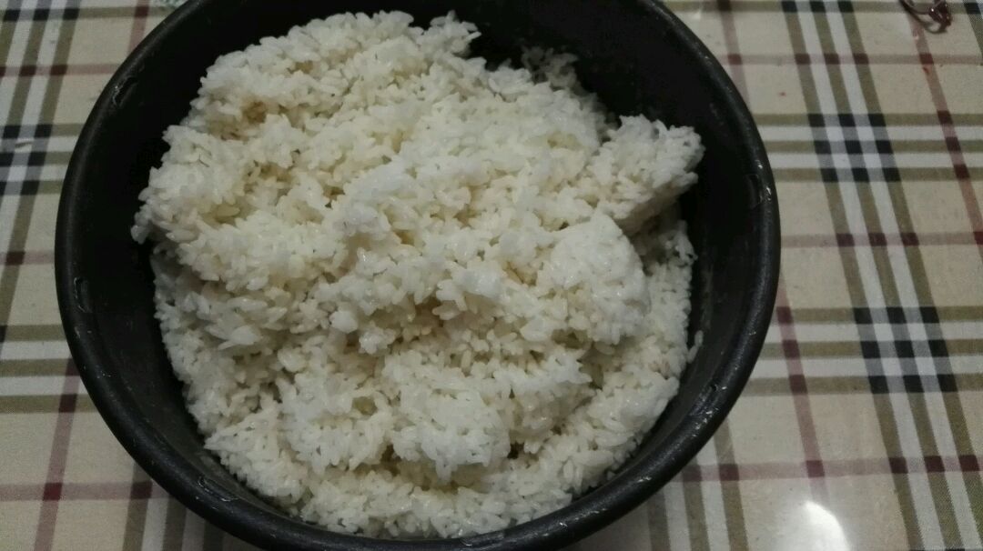 煮好的米饭,在电饭煲中翻拌开,或者放入到无油无生水的盆子里,晾凉.