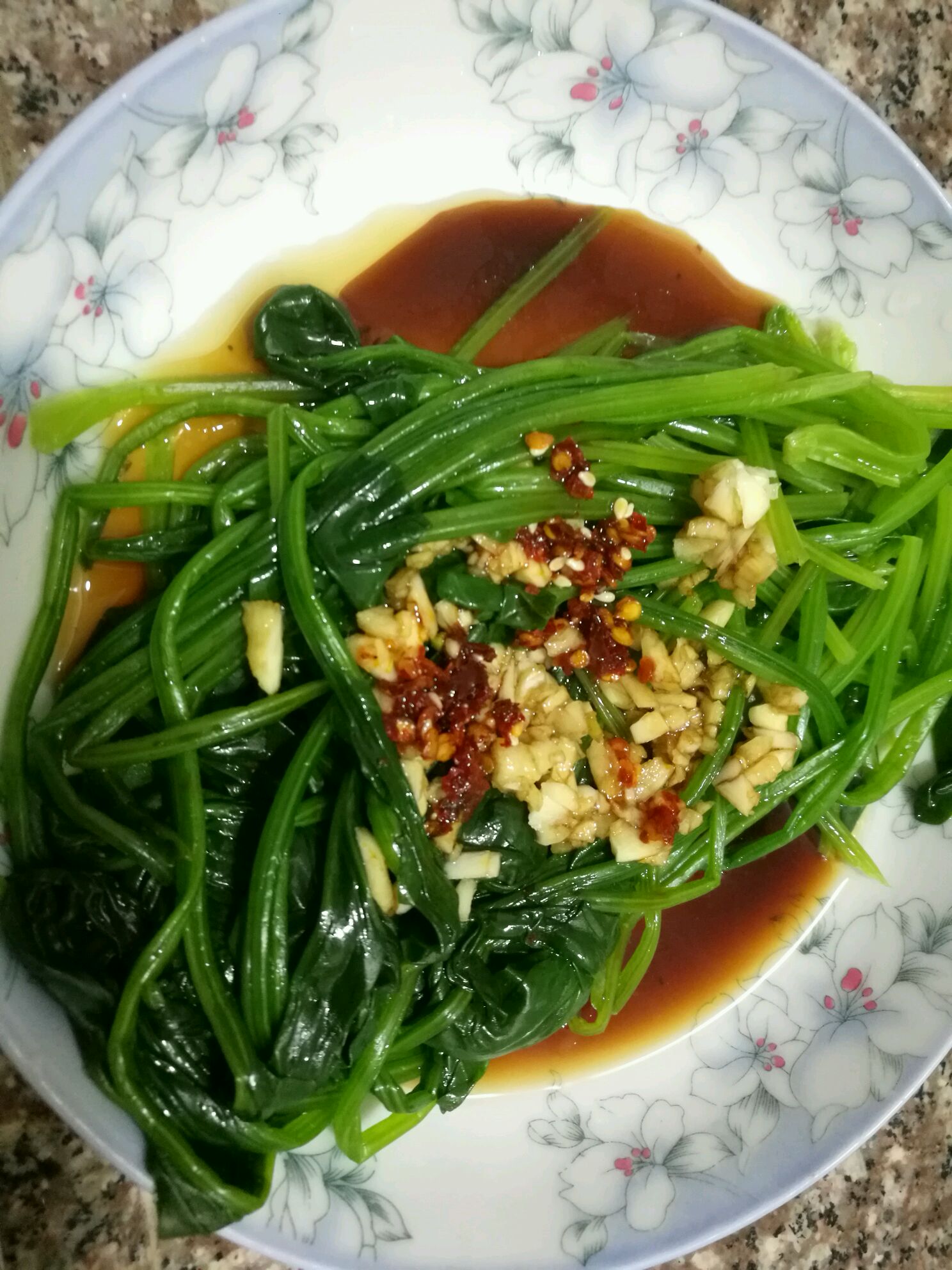 将捞出后装盘,洒上蒜蓉,浇上香油,辣椒油和调好的酱料,就可以吃