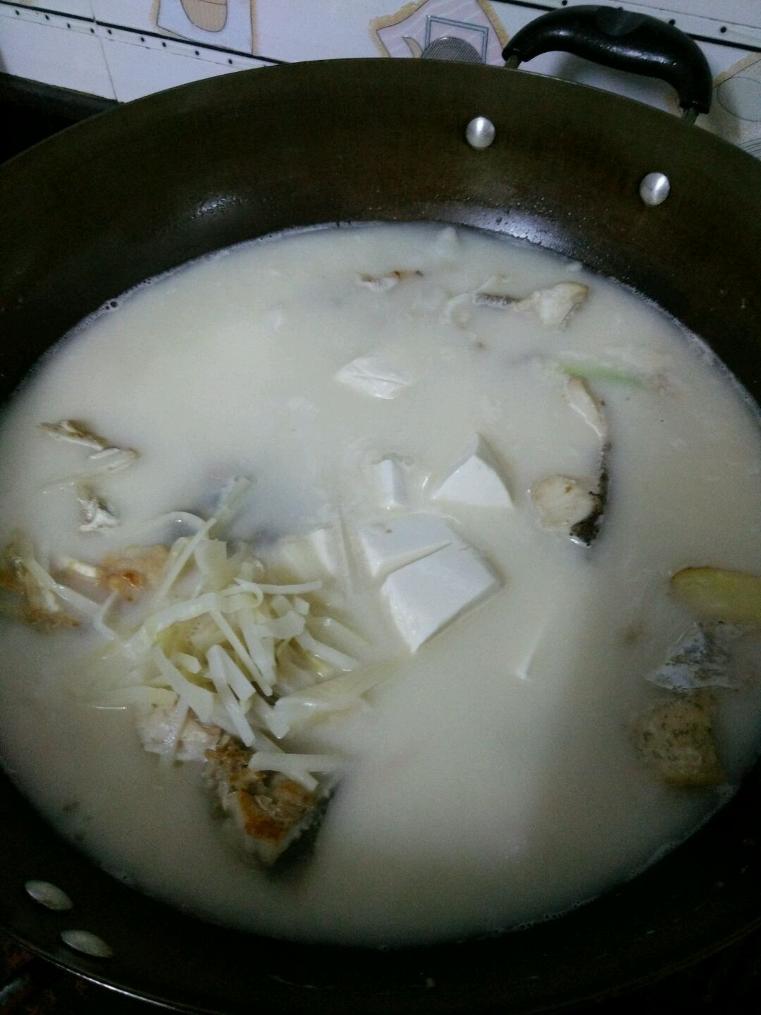 煮到鱼汤成奶白色时放入豆腐,酸笋,烧开,放适量盐,尝试味道