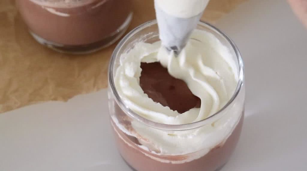 在热巧克力上按照画圈的方式从外到里挤上奶油.