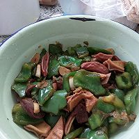 油热后,放入葱和蒜炒出香味,放入青椒,快熟时加味达美和盐,放入猪杂