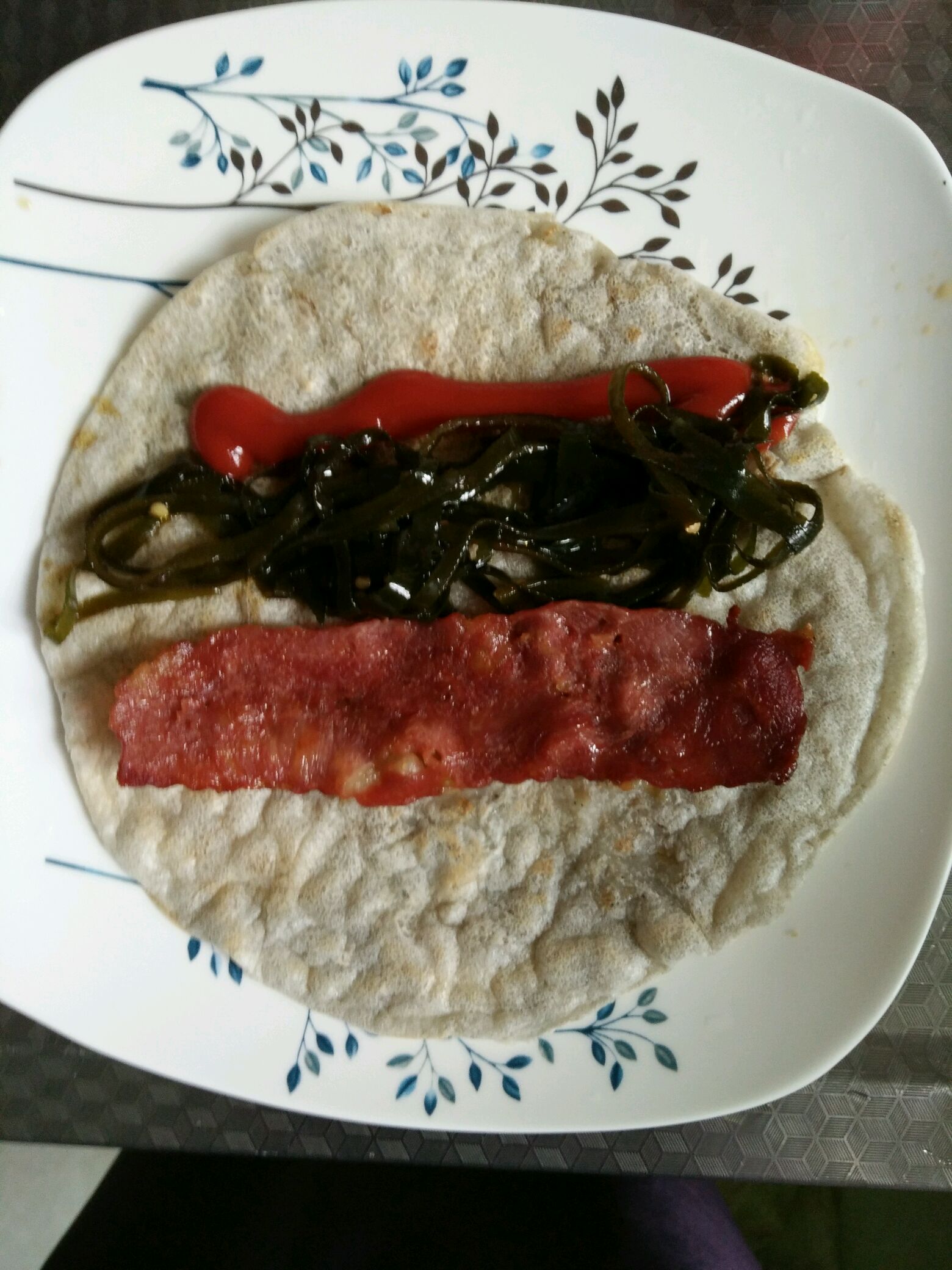 煎好的饼平铺盘子上 摆料 我放的是番茄酱 海带丝 培根 也可以放火腿