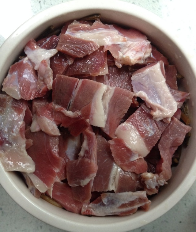 腊肉切好平铺在黄花菜上面,锅里放水 