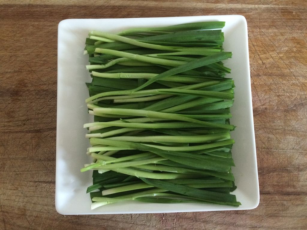 切好韭菜摆入盘中,把孜然粉,辣椒粉,椒盐混合在一起撒在韭菜上面