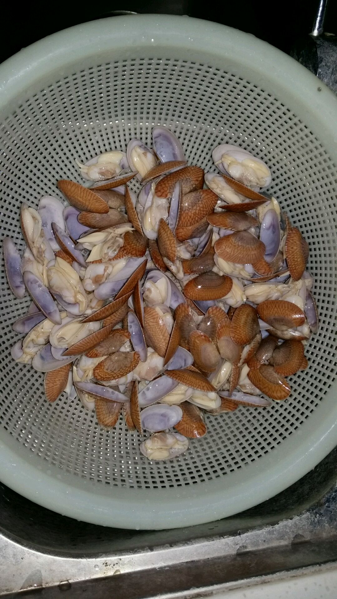 煮开壳的花甲螺,放水龙头下用清水冲洗,这样可以把贝壳里的泥沙冲洗