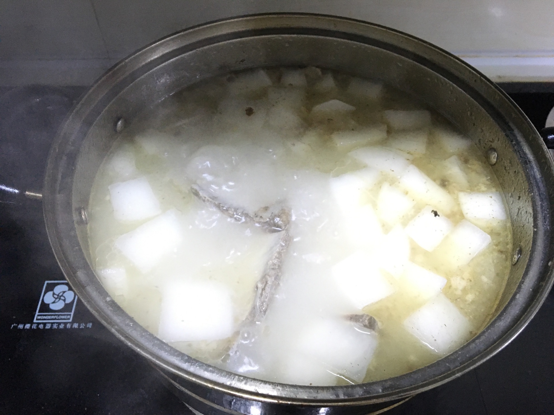 将猪骨洗干净,放进水里煮去血水,将葱姜料酒和白萝卜一起放入锅里煮2