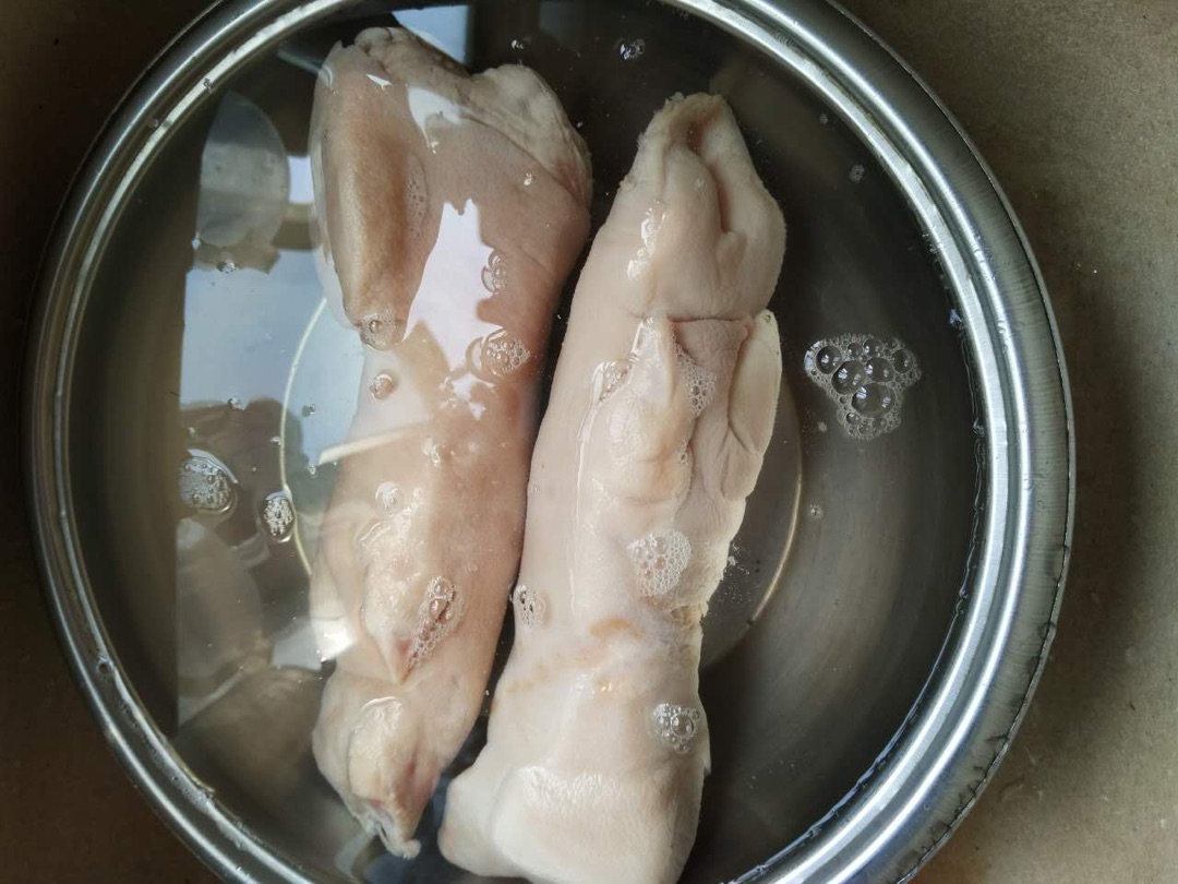用火烧猪蹄上的毛,用益之源净水器的水浸泡,放上碟新15分钟,去除异味