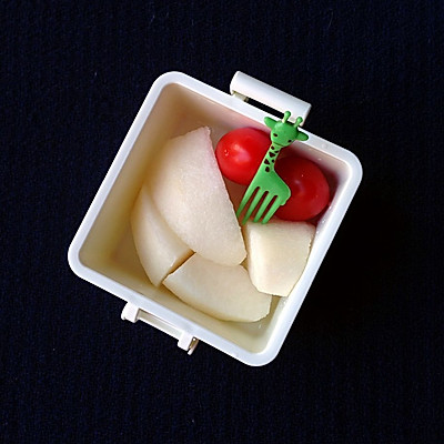 4.梨子切好,放盐水里过一下.和洗净的小番茄一起装入水果盒.